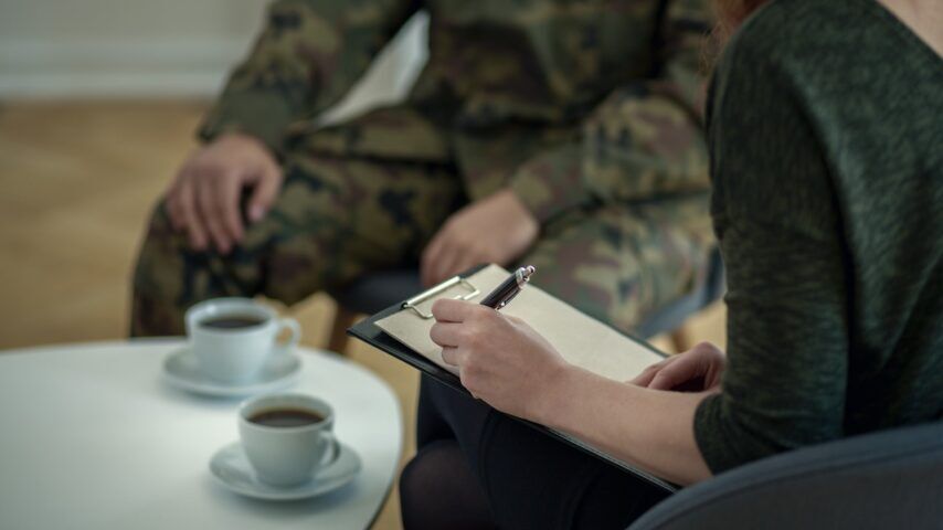 Close-up of psychologist writing down notes while talking to her patient in Pennsylvania rehab center