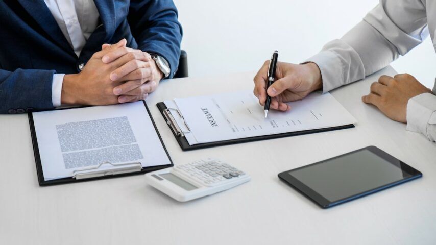 A man signing an Anthem BCBS insurance form after the agent explained the coverage for drug rehab