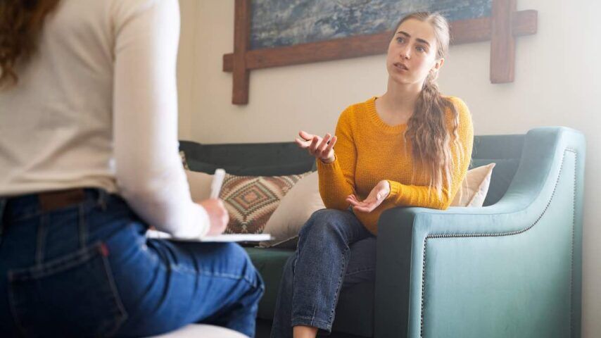 Young woman talking to psychologist during her adderall addiction therapy session